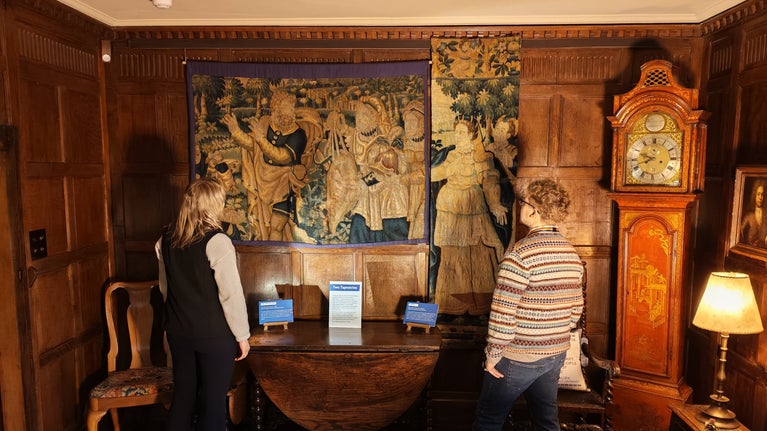 Two people looking at the tapestries on display at Packwood House, Warwickshire as part of their Common Threads Exhibition